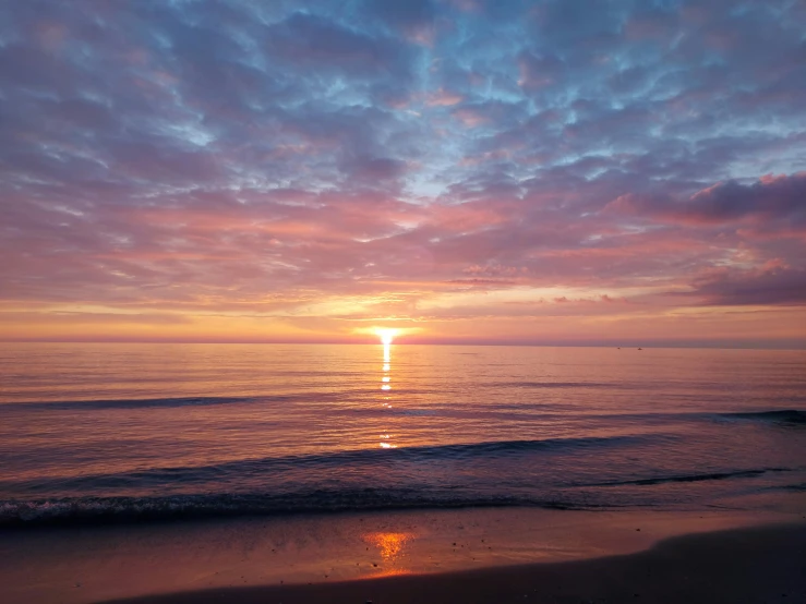 the sun is setting over the ocean on the beach, pexels contest winner, orange / pink sky, waking up, multicolored, february)