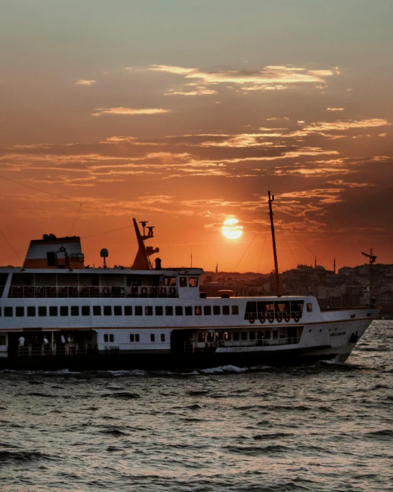 a large boat floating on top of a body of water, watching the sunset, istanbul, lgbtq, multiple stories