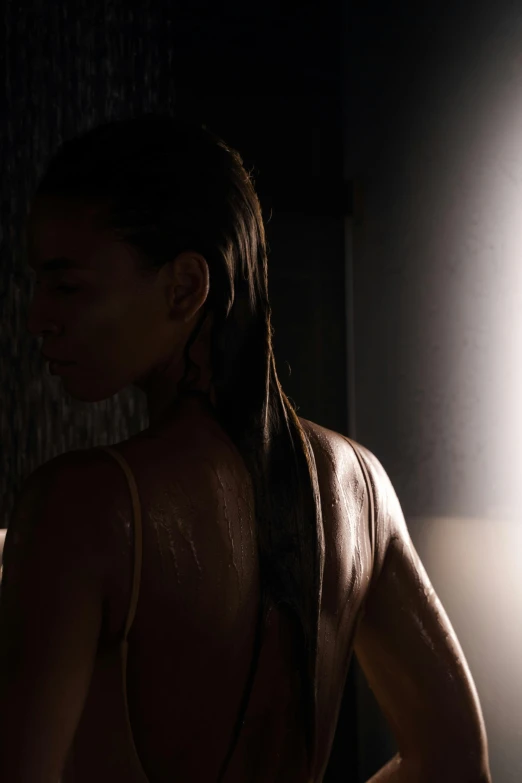 a woman standing in the dark with her back to the camera, hyperrealism, under a shower, unreal engine 5 lighting, afternoon sun, shot on sony a 7