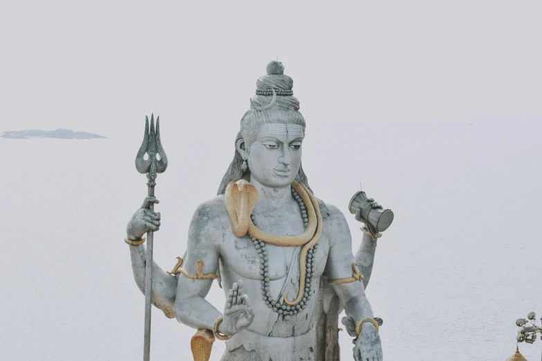 a statue sitting on top of a snow covered ground, pexels contest winner, samikshavad, god shiva the destroyer, 🦩🪐🐞👩🏻🦳, wearing long silver robes, who is born from the sea