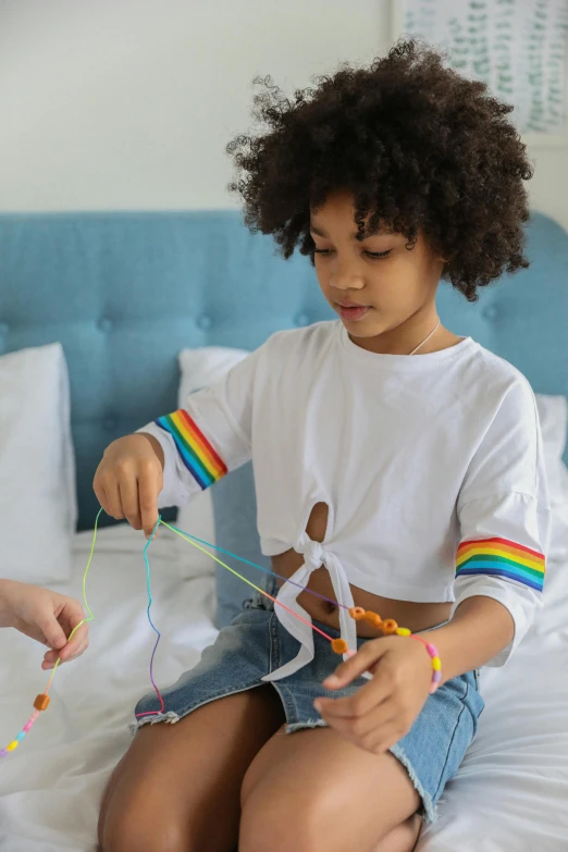 a couple of kids sitting on top of a bed, a child's drawing, pexels contest winner, tied - up shirt, rainbow accents, holding a magic needle, childish gambino