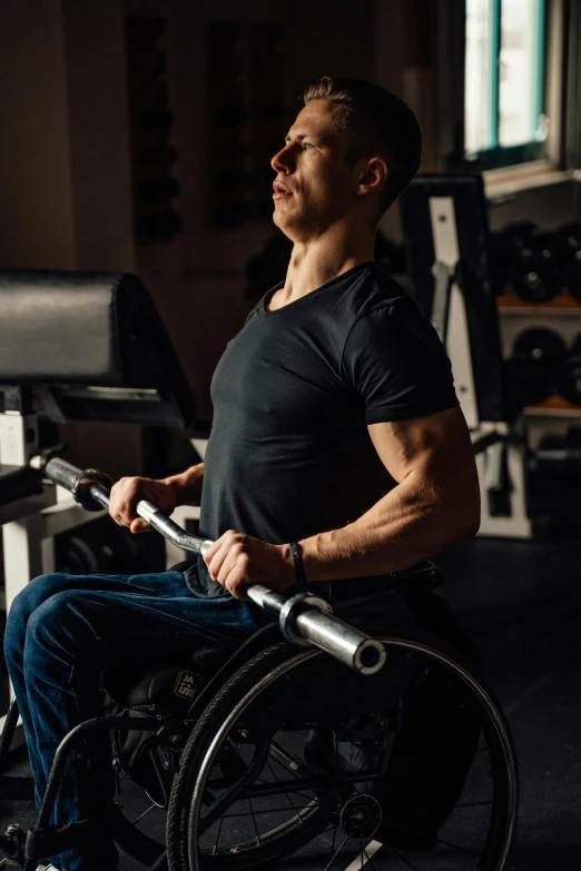 a man in a wheelchair in a gym, an album cover, trending on pexels, muscular build, (extremely detailed, strong light, thumbnail