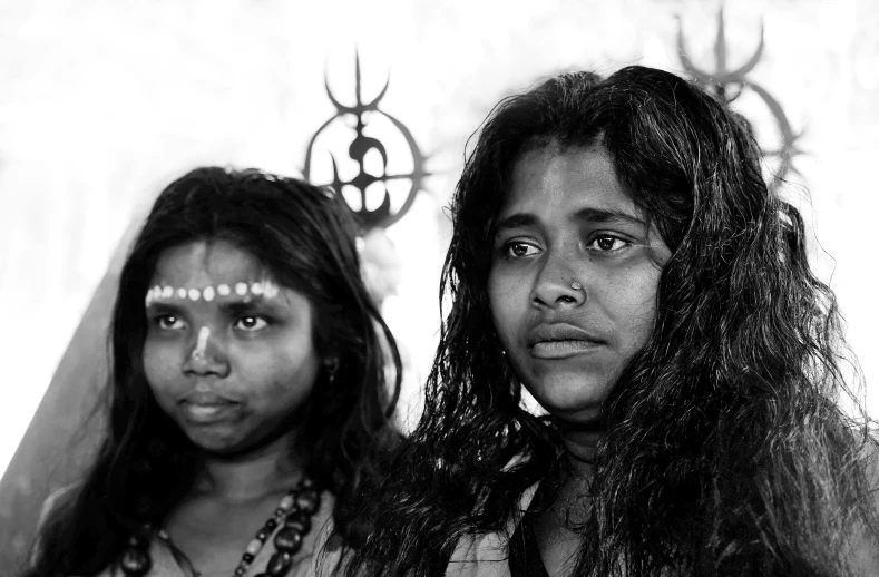 a couple of women standing next to each other, a black and white photo, by Sudip Roy, pexels contest winner, sots art, beautiful young female shaman, closeup faces, sirius a and sirius b, two girls