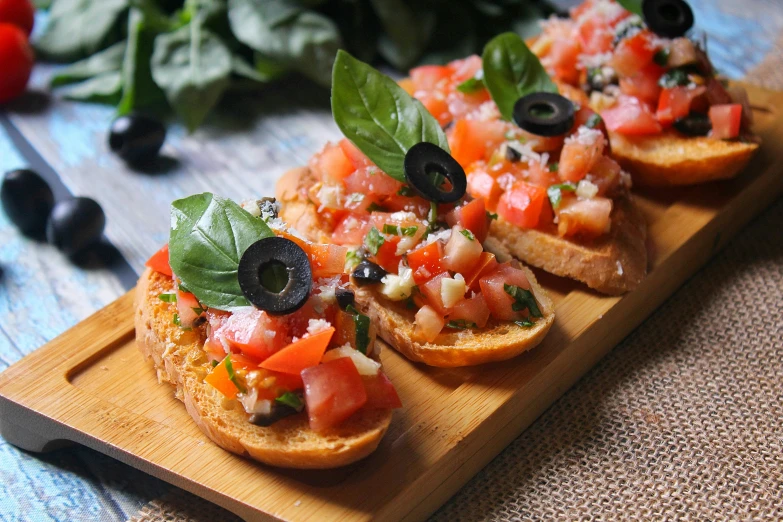 a wooden cutting board topped with lots of food, basil gogos, thumbnail, pointè pose, tomato