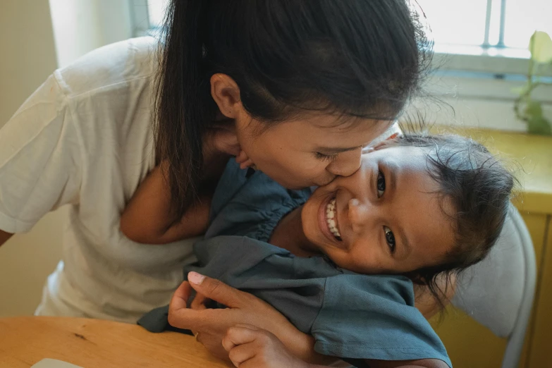 a woman holding a child in front of a laptop, pexels contest winner, hurufiyya, loving embrace, thumbnail, manuka, smiling down from above