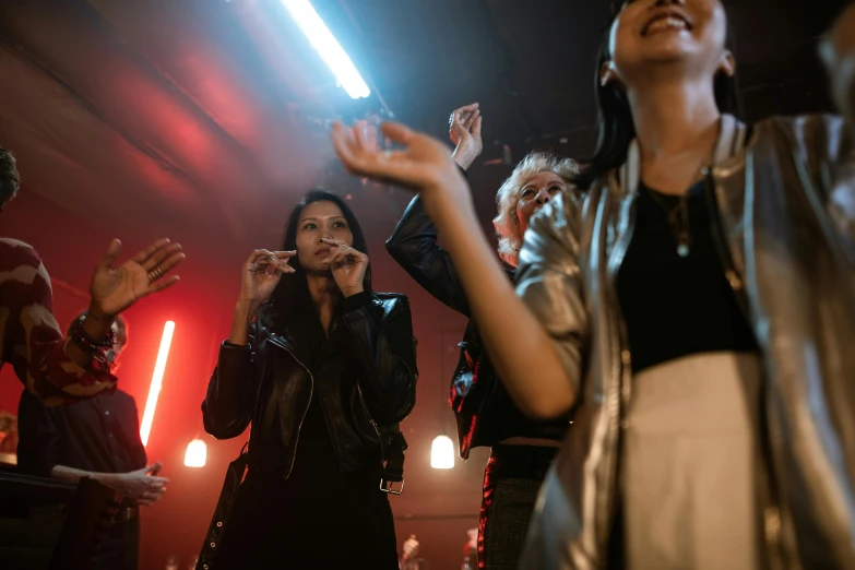 a group of people standing on top of a stage, an album cover, pexels, leather clothing, other women dancing behind, scene from church, [ cinematic