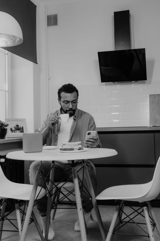 a man sitting at a table using a laptop computer, a black and white photo, by Romain brook, having a snack, matteo salvini, gif, high quality image