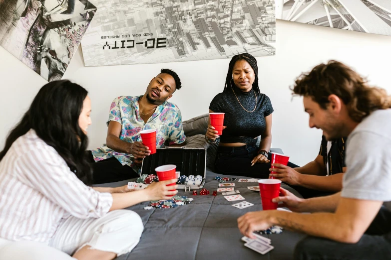 a group of people sitting around a table, playing, profile image, coke and chips on table, squad