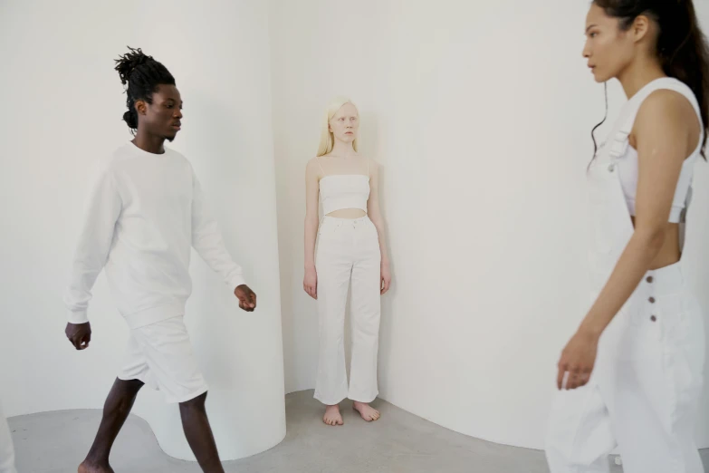 a couple of people that are standing in a room, inspired by Vanessa Beecroft, trending on unsplash, renaissance, casual white garment, three women, white pants, photoshoot for skincare brand