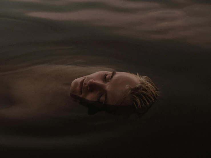 a man floating on top of a body of water, an album cover, inspired by Elsa Bleda, unsplash contest winner, massurrealism, face and skin is dark red, julia hetta, portrait featured on unsplash, relaxing