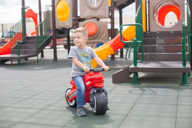 a young boy riding a red tricycle in a playground, a picture, product view, octane fender, fisher price redwood forest, motorbike