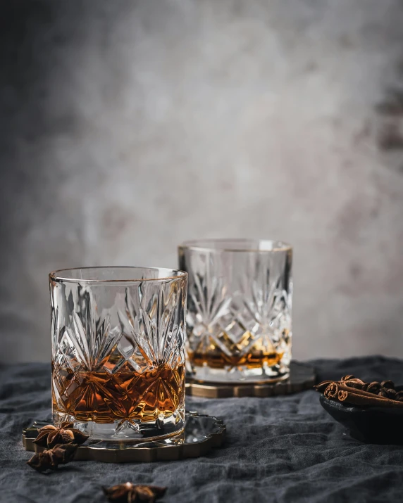 two glasses of whiskey sitting on top of a table, inspired by Alexander Fedosav, unsplash, baroque, textured base ; product photos, malaysian, spiky, award - winning crisp details ”