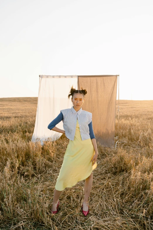 a woman in a yellow dress standing in a field, by Winona Nelson, cropped shirt with jacket, longque chen, slide show, ashteroth