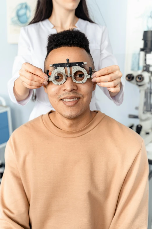 a woman is putting a pair of glasses on a man's head, brown holes, male physician, zoomed out, uploaded