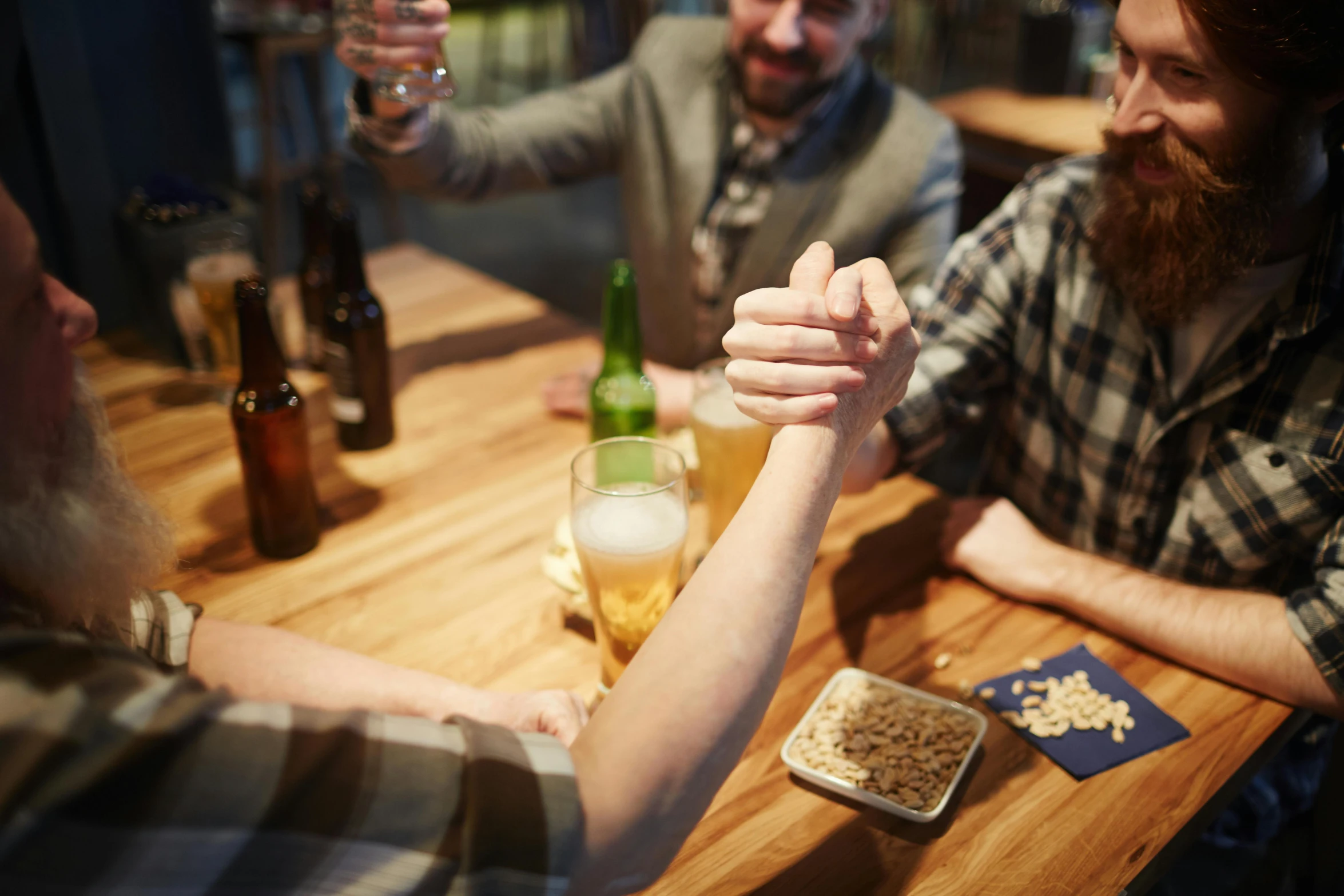 a group of people sitting around a wooden table, pexels contest winner, drunken fist, closeup of arms, nightcap, aussie baristas