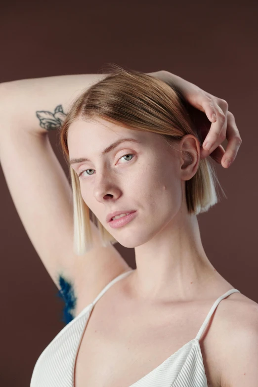 a woman brushing her hair in front of a mirror, a character portrait, inspired by Elsa Bleda, trending on pexels, hyperrealism, die antwoord yolandi portrait, plain background, with a bob cut, 5 0 0 px models