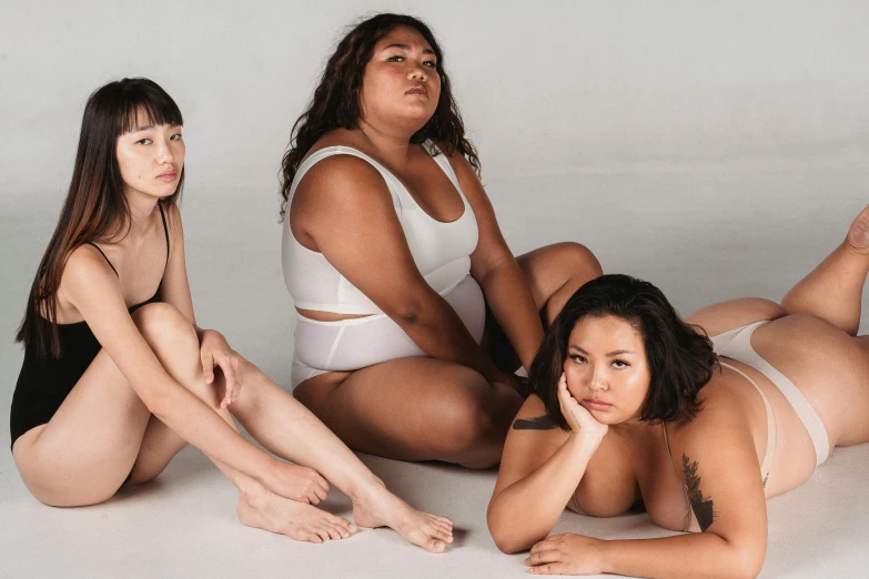 a group of women sitting on top of a white floor, inspired by Vanessa Beecroft, unsplash, plus size woman, half asian, is wearing a swimsuit, ilustration