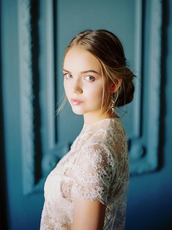 a woman standing in front of a blue wall, inspired by Elsa Bleda, trending on unsplash, renaissance, bride, ukrainian girl, portrait. 8 k high definition, dressed in a lacy