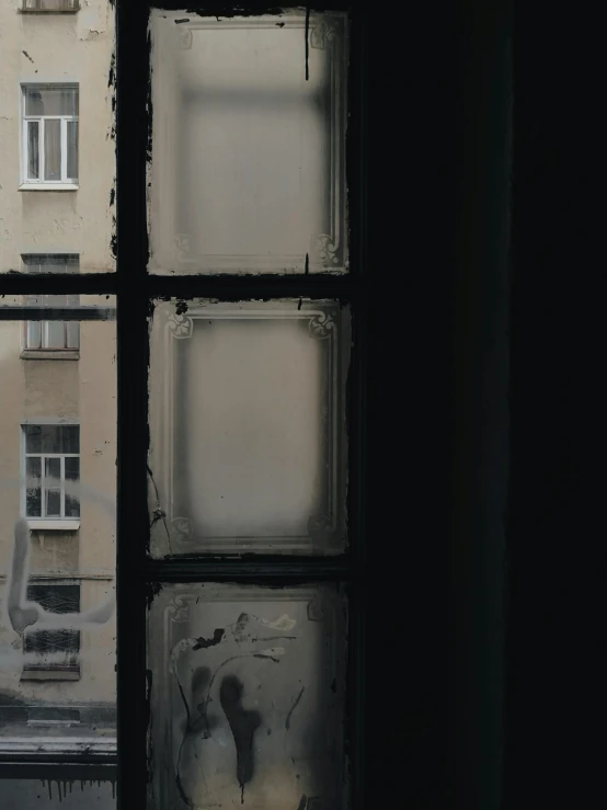 a view of a building through a window, inspired by Elsa Bleda, pexels contest winner, graffiti, gray fog, squares, sovietwave aesthetic, black windows