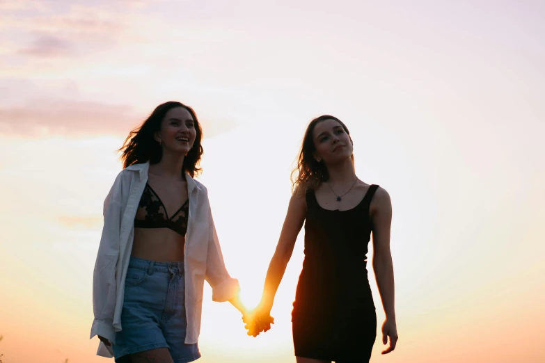 two women standing next to each other holding hands, trending on pexels, happening, summer evening, sydney hanson, attractive girl, lesbian