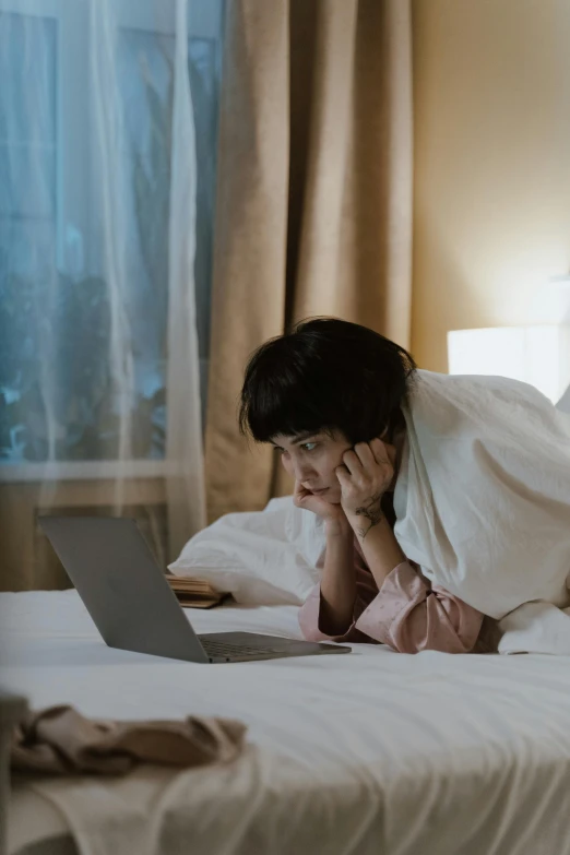 a woman laying on a bed with a laptop, pexels contest winner, happening, scene from a movie, bending down slightly, asian woman, hotel room