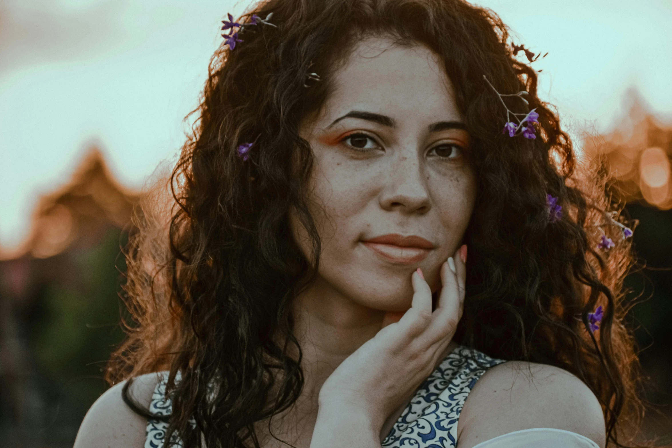 a woman with curly hair and flowers in her hair, pexels contest winner, early evening, portrait image, olive skin color, casual pose