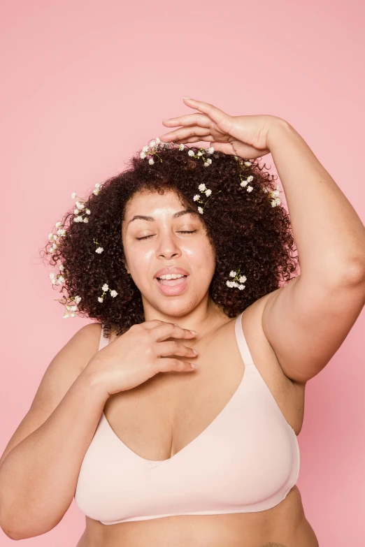 a woman in a bra top with flowers in her hair, trending on pexels, double chin, hands shielding face, curvy build, ad image