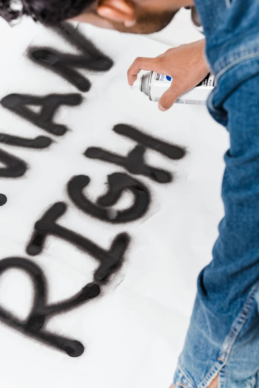 a close up of a person writing on a sheet of paper, an airbrush painting, inspired by Sigmar Polke, trending on unsplash, graffiti, black on white background, bubble letters, high angle, say ahh