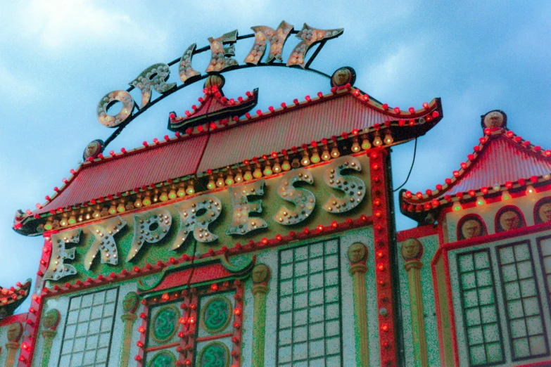 a colorful building with a sign above it, pexels contest winner, art nouveau, chinese empress, big top circus tent, green, memphis