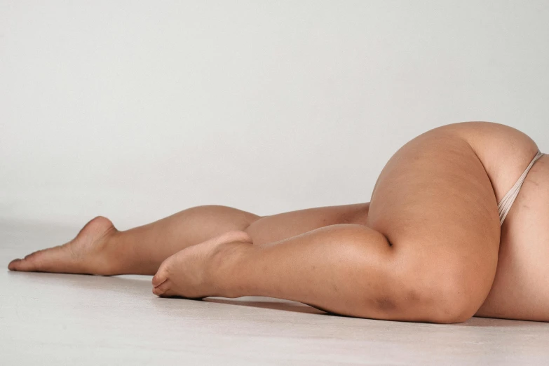 a woman in a bikini laying on the floor, inspired by Sarah Lucas, unsplash, thick thighs, realistic anatomical proportions, bending down slightly, on a white table