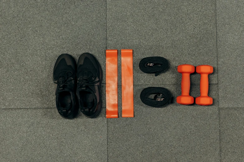 a pair of black shoes next to a pair of orange dumbs, pexels contest winner, postminimalism, athletic crossfit build, various items, rectangle, foot wraps