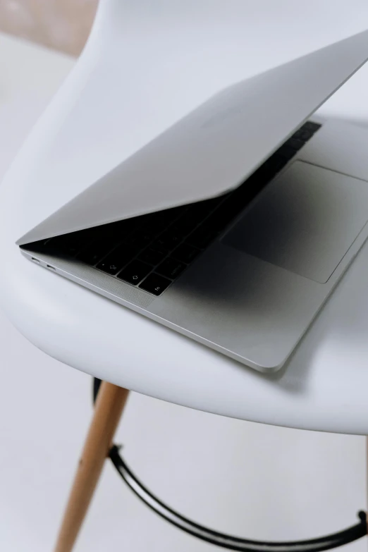 a laptop computer sitting on top of a white chair, by Carey Morris, rounded shapes, close up image, rounded roof, white table