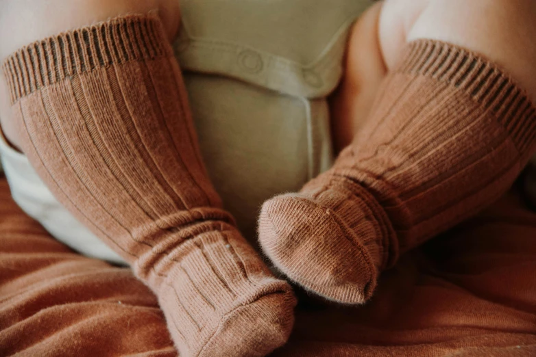 a close up of a person wearing a pair of socks, by Emma Andijewska, trending on pexels, wearing a brown, toddler, a pair of ribbed, cinnamon skin color