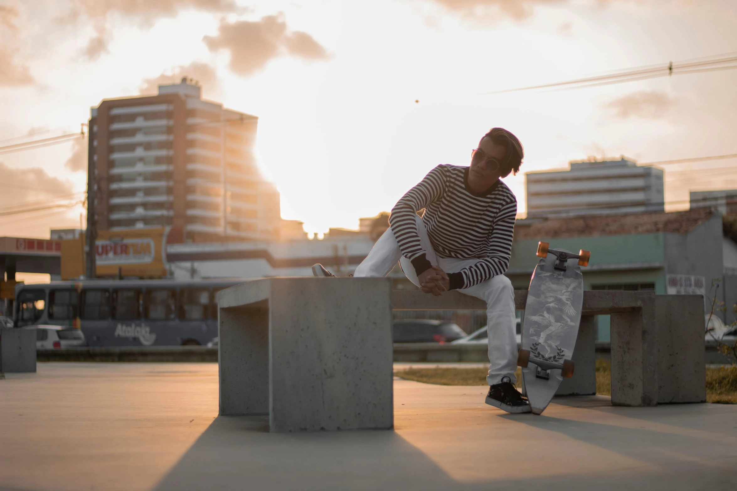 a man riding a skateboard on top of a cement block, by Niko Henrichon, pexels contest winner, sitting on a park bench, alana fletcher, riyahd cassiem, sundown