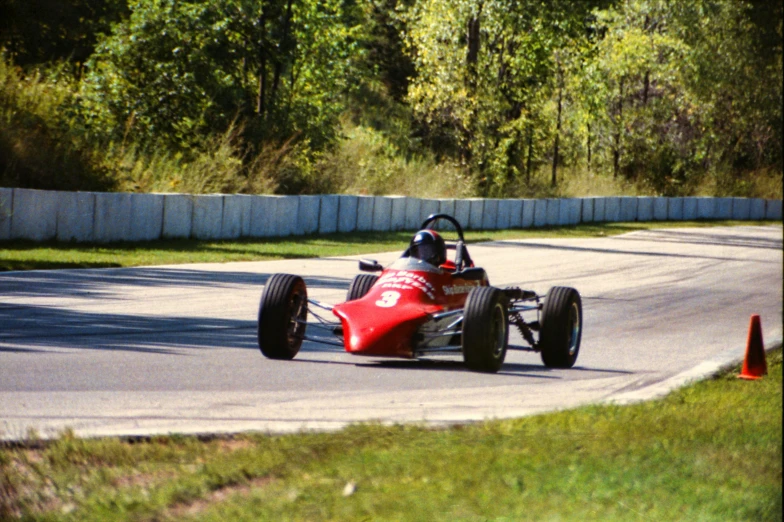 a man driving a red race car down a road, old school fpr, michigan, formulas, photo taken with provia