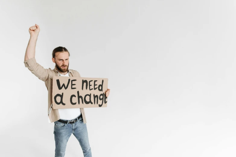 a man holding a sign that says we need change, trending on pexels, avatar image, background image, cardboard cutout, sustainability