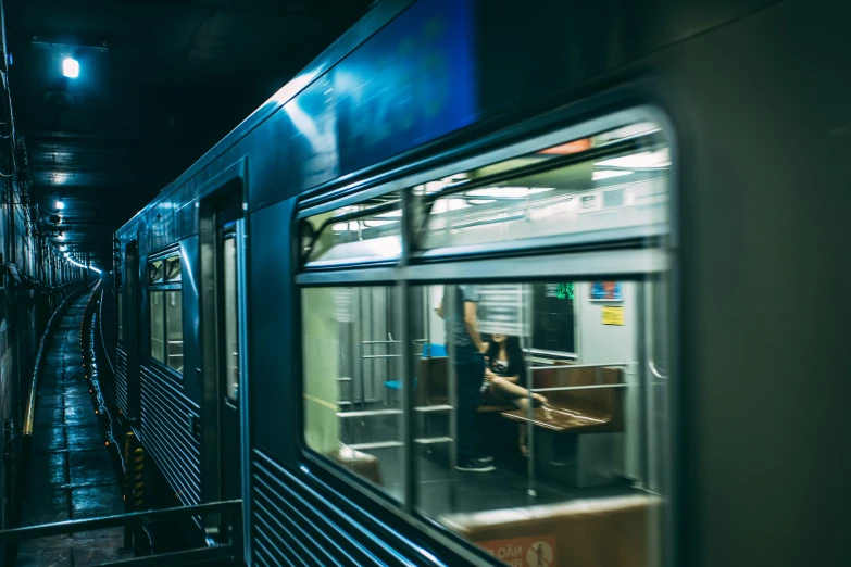 a person sitting on a bench in front of a train, by Andrew Domachowski, unsplash contest winner, open window at night, chicago, inside of a metro train, inside of a car