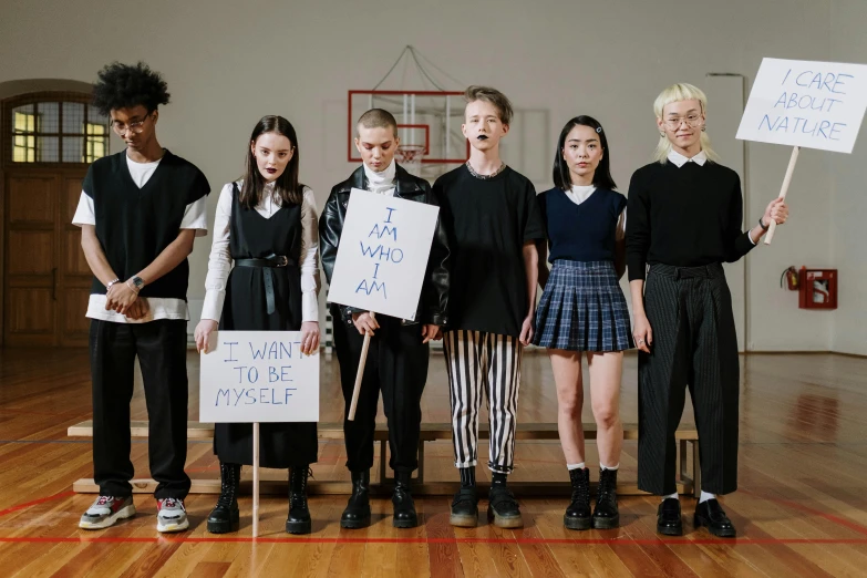 a group of young people standing next to each other holding signs, by Anna Findlay, unsplash, antipodeans, dressed as schoolgirl, hito steyerl, still from a music video, erwin olaf