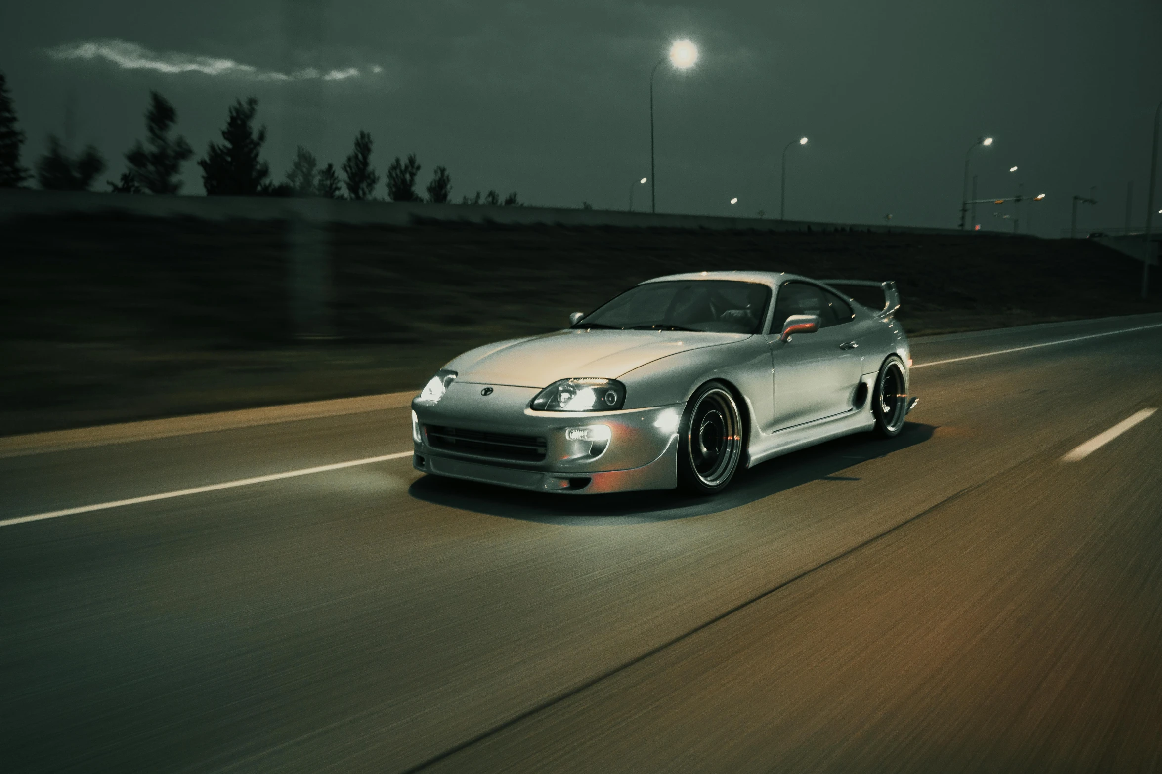 a silver car driving down a road at night, inspired by Taiyō Matsumoto, unsplash contest winner, photorealism, toyota supra, 90s photo, high detail 4 k, desaturated!