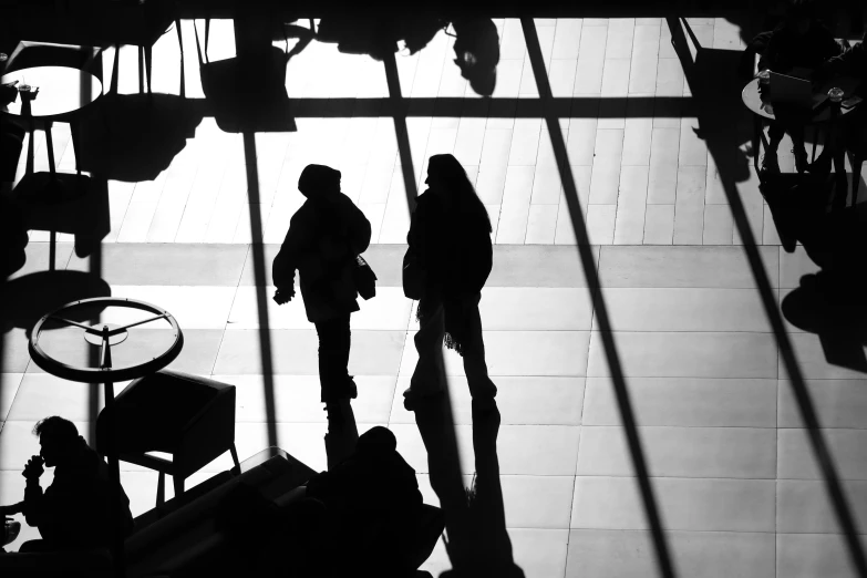 a couple of people that are standing in a room, by Dave Melvin, flickr, traversing a shadowy city, black. airports, winter sun, by greg rutkowski