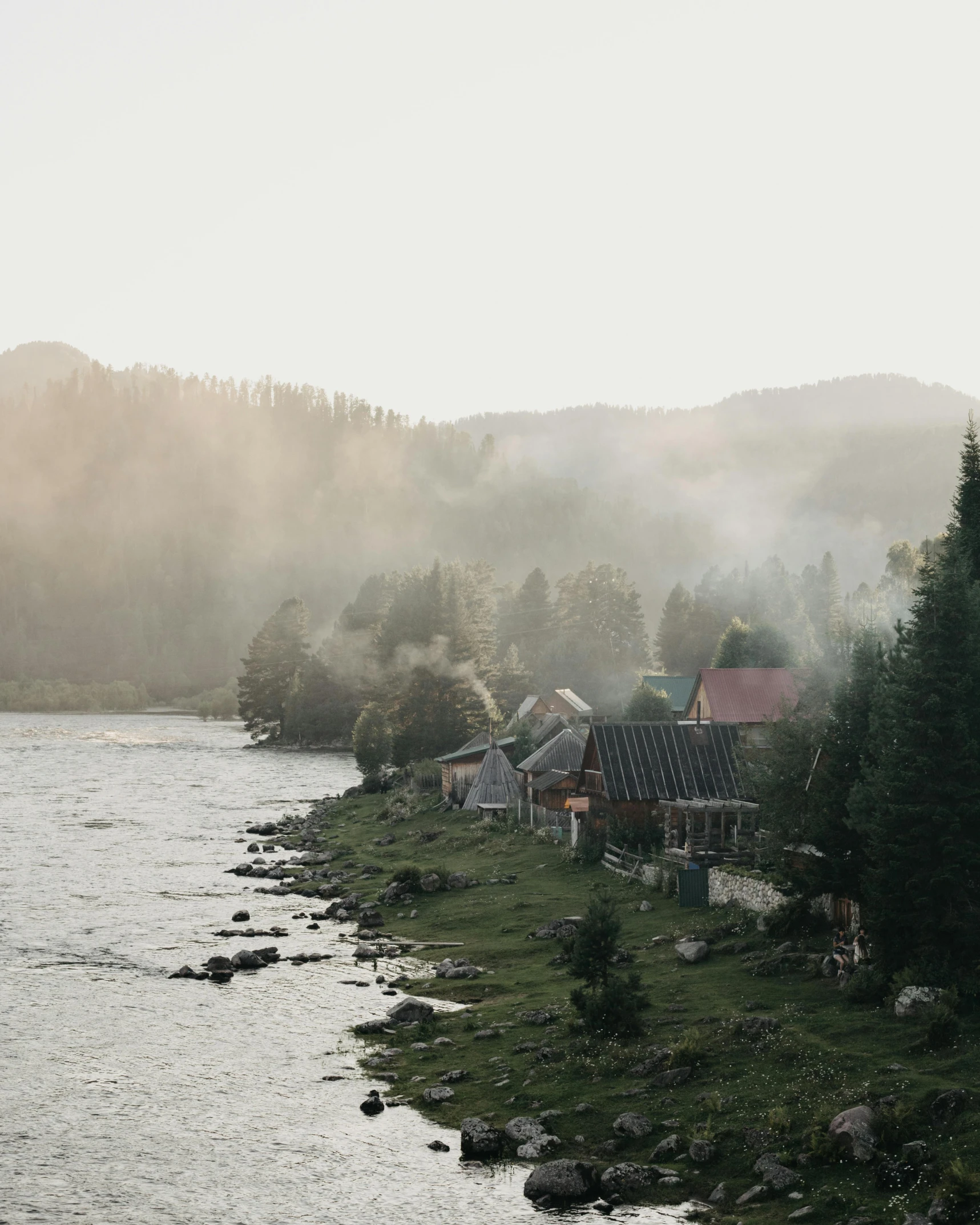 a river running through a lush green forest filled with trees, by Emma Andijewska, pexels contest winner, burning village in background, foggy evening, river running past the cottage, mongolia