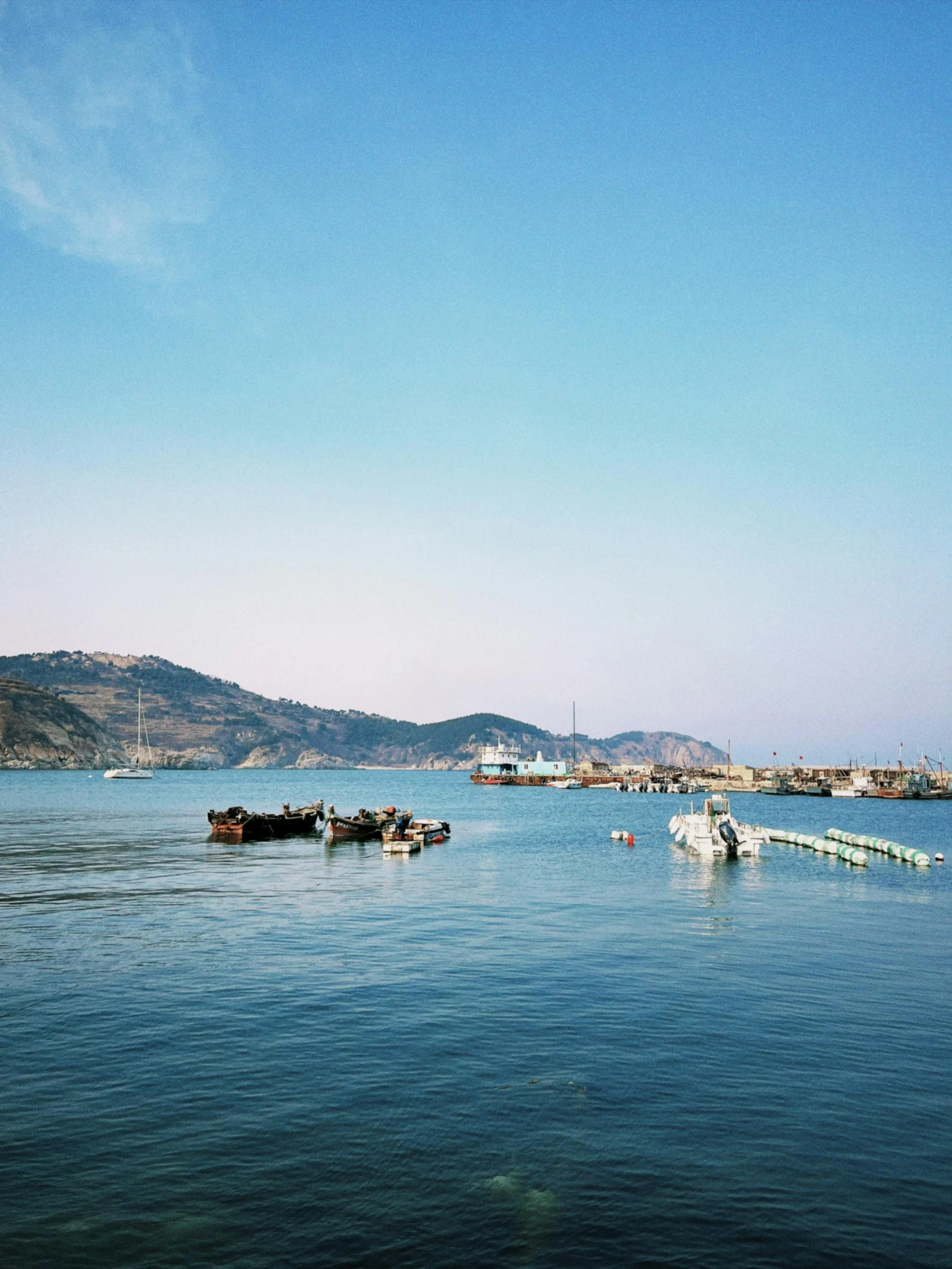 a group of boats floating on top of a body of water, inspired by Zhang Kechun, pexels contest winner, 1960s color photograph, italian mediterranean city, medium format. soft light, nagasaki