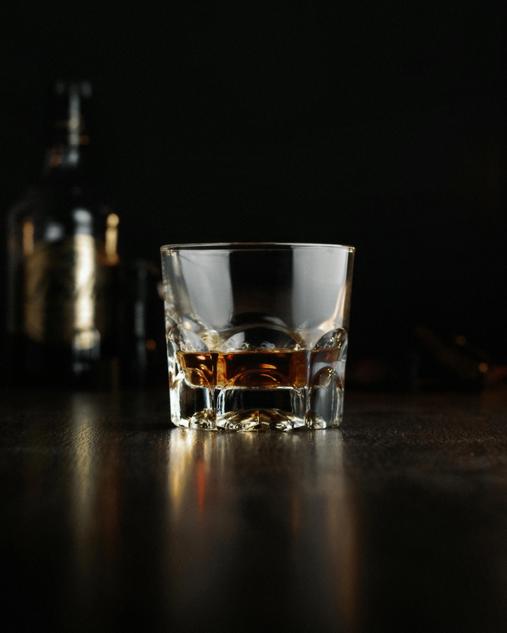 a glass of whiskey sitting on top of a wooden table, unsplash, panel of black, studio medium format photograph, multiple stories, miniature product photo