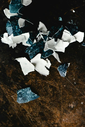 a broken cell phone sitting on top of a wooden table, an album cover, unsplash, abstract expressionism, shattered crumbling plaster, dark blues, strong eggshell texture, [ shards