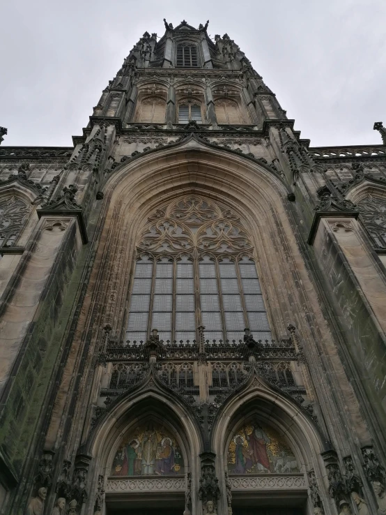 a tall building with a clock on the front of it, international gothic, dark gothic cathedral, slight overcast weather, towering high up over your view, looking towards the camera