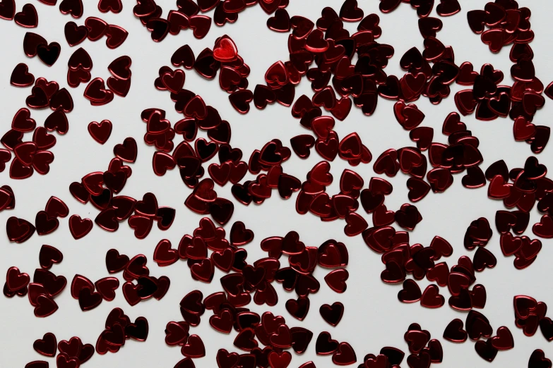 a white table topped with lots of red hearts, pexels, computer art, metallic red, garnet, detailed product shot, chrome red