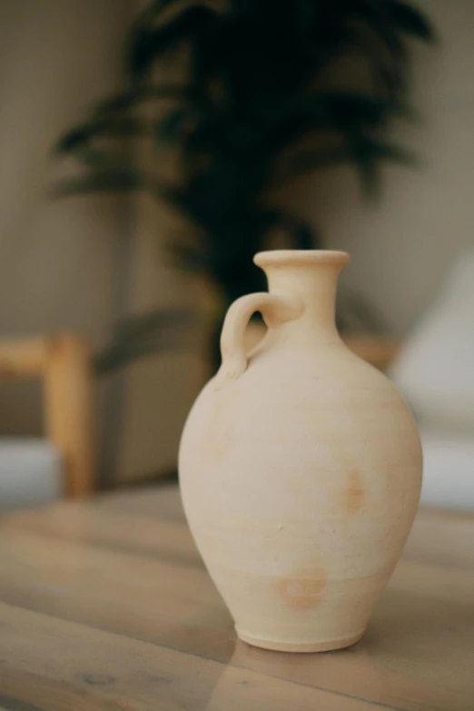 a white vase sitting on top of a wooden table, by Hendrik Gerritsz Pot, unsplash, morocco, sand color, 15081959 21121991 01012000 4k, small stature