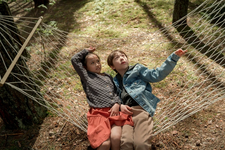 two children sitting in a hammock in the woods, happening, at netflix, in karuizawa, sony pictures, promotional image