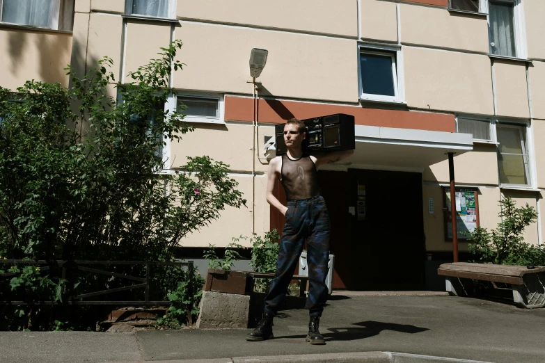 a man that is standing in front of a building, by Attila Meszlenyi, holding electricity, posing for a fight, maintenance photo, neighborhood