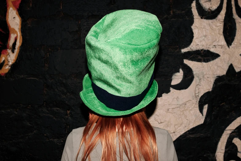 a woman with red hair wearing a green hat, an album cover, by Joe Bowler, unsplash, grim-hatter, irish, photo from the back, celebration